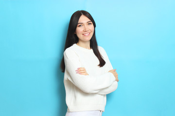 Beautiful girl in a warm cozy sweater on a colored background.