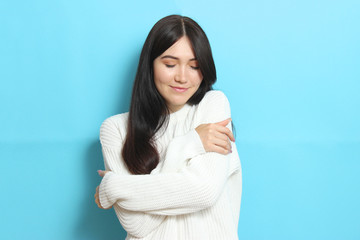 Obraz premium Beautiful girl in a warm cozy sweater on a colored background.
