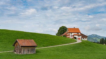 Obraz premium Beautiful swiss farm house on the hill