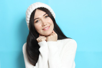 Beautiful girl in a warm cozy sweater on a colored background.