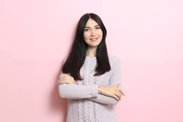Fototapeta premium Beautiful girl in a warm cozy sweater on a colored background.