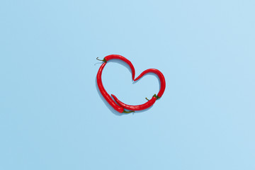 Chili pepper heart shape on blue background, Chili flat lay