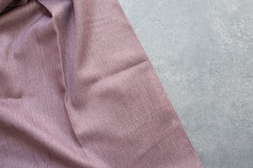 Fabric sample on the table. The designer workplace concept. Freelance fashion comfortable femininity workspace in flat lay style on gray background. Top view, pink color palette