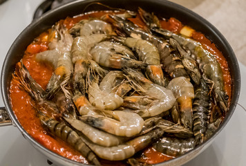 Delicious Tiger Prawns or Shrimps in tomato sauce and herbs on a pan. Italian cuisine.