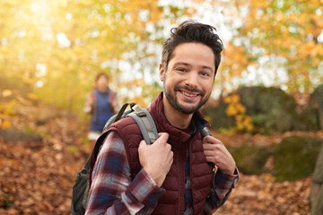 Attractive caucasian couple hiking through the forest in the fall in Canada