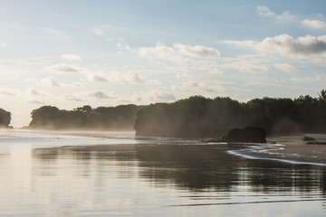 Black Beach with waves, rocks and reflection water surface