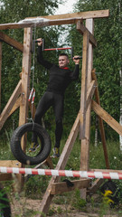 Man passing through hurdles during obstacle course in boot or sport competition