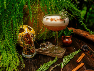 Brown cocktail in a glass goblet on a long leg. In the tropical garden. On a flat stone.
