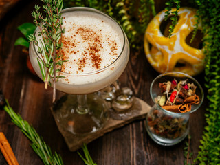 Brown cocktail in a glass goblet on a long leg. In the tropical garden. On a flat stone.