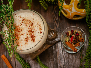 Brown cocktail in a glass goblet on a long leg. In the tropical garden. On a flat stone.