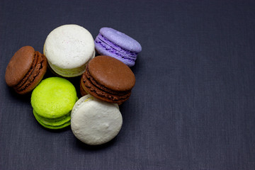 Colorful macaroons or macaroni cake on a dark background. A french sweet delicacy