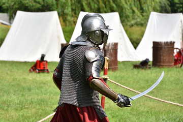 Medieval Polish knight in a chainmail and shishak helmet with a sabre. Historical reenactment in Brodnowski park in Warsaw, Poland - 281628597
