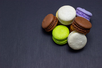 Colorful macaroons or macaroni cake on a dark background. A french sweet delicacy
