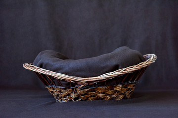 Background for shooting newborns. Wooden basket on a dark background. Close-up.