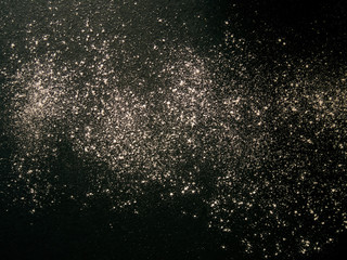 Abstract background. White flour spots on black. Top view on blackboard.