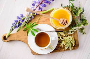 Cup with herbal tea and honey and dry herbal tea