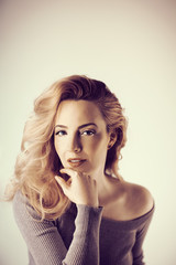 Fototapeta premium Beautiful young woman with long curly hair and natural make up beauty portrait, looking into camera