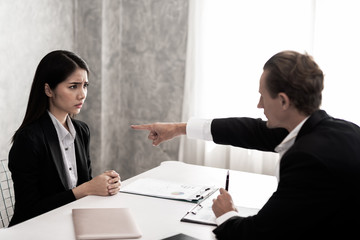 Young business women in black suit are stressed. Boss complaints at the desk in the Office work in...