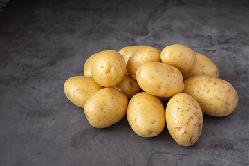 Young potatoes on a dark background.Crop. Harvest