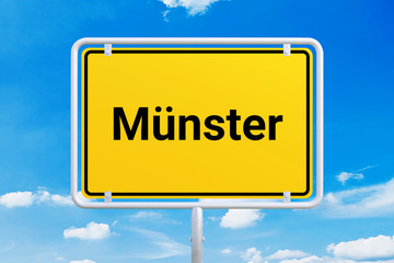Stadt Münster. Gelbes Schild, Ortsschild, Ortseingangsschild. Himmel mit Wolken.