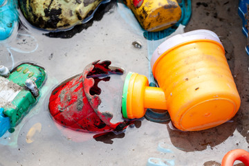 Flooded sandpit with toys after the rain