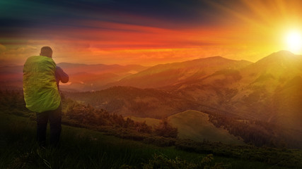 Autumn landscape with mountain, valley and lagoon views. The slopes of the hill are covered with scarlet arctous. Amazing sunset with sun rays over the mountains.