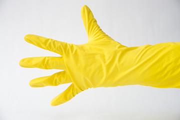 Fototapeta na wymiar hand in yellow glove open palm, white background, fingers in different directions,
