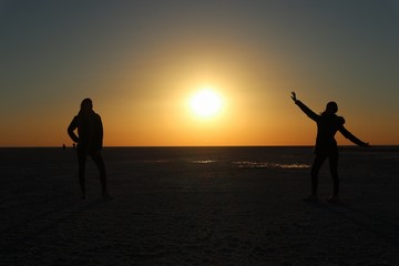 silhouette of man and woman on the beach at sunset