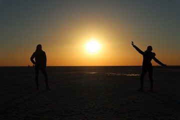 Fototapeta premium silhouette of man and woman on the beach at sunset