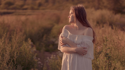 Portrait of a girl in a white dress on a background of summer nature