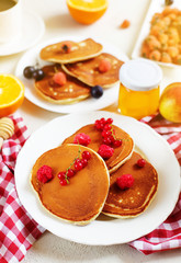 Healthy summer breakfast,homemade classic american pancakes with fresh berry and honey, morning light white stone background copy space top view