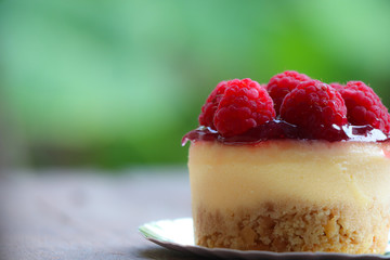 Raspberry cheese cake sweet bake topping with fruit on wood background