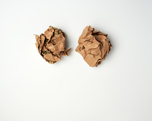 two crumpled sheets  of brown paper on a white background
