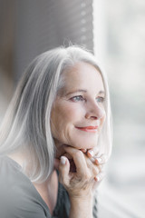 stunning beautiful and self confident best aged woman with grey hair smiling into camera, portrait 