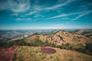 Obraz premium Green Hills and Mountains with Trees Under Blue Sky on Sunny Day