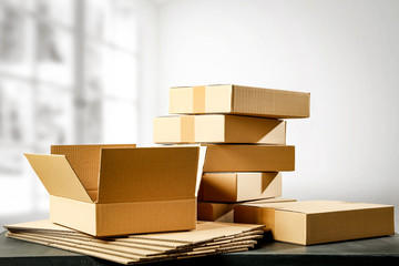 Boxes in a pile on a table top on a white wall background. Some parcel to send.