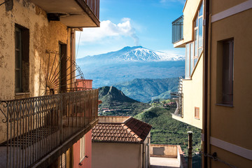 Amazing view of the snowy Volcano Etna among the old buildings, Castelmola