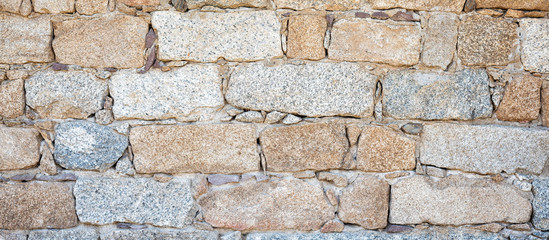 Detail of an old stone wall arranged in an irregular manner. Architecture constructions. Vintage background.