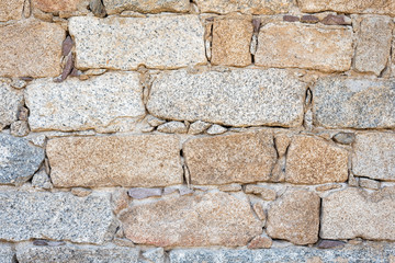 Detail of an old stone wall arranged in an irregular manner. Architecture constructions. Vintage background.