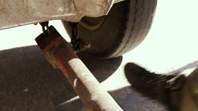 Mechanic hands Towing Car with Towing Metal Stick. Close-Up. 
