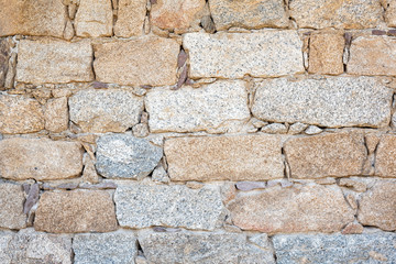Detail of an old stone wall arranged in an irregular manner. Architecture constructions. Vintage background.