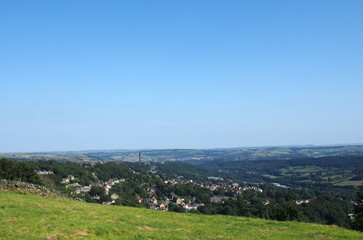 Fototapeta na wymiar a panoramic view of halifax from above surrounded by Fields and pennine hills and a blue summer sky