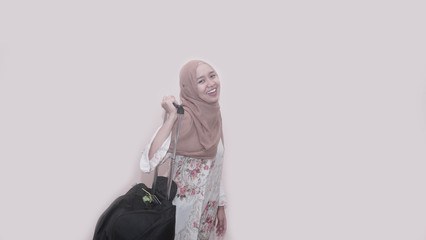 Portait of asian muslim woman wearing head scarf or hijab holding suitcase luggage
