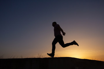 silhouette of man running at sunrise