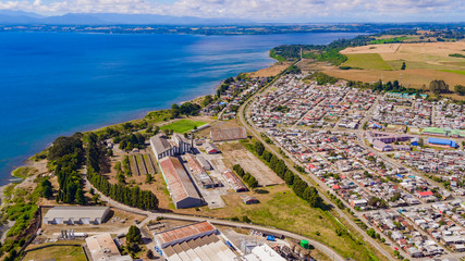 Fototapeta na wymiar Aerial view of the town of Llanquihue on a sunny day. you can see how households live together with industries