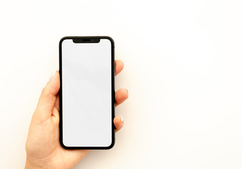 Woman's hand holding the black smartphone with big blank screen isolated on white. Top view mockup horizontal banner
