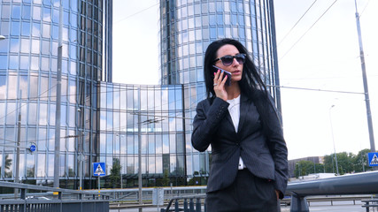 Happiness businesswoman calling by phone on the business architecture background. Concept of: Skyscraper,  Business girl, Architect, Lifestyle.