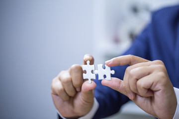 Business woman hands connecting jigsaw puzzle. Business solutions, success and strategy concept. Businessman concept.