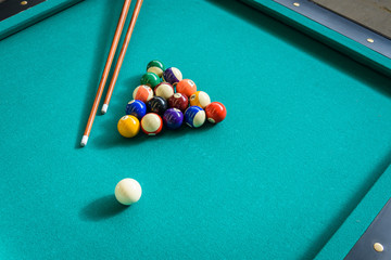 Bolas de billar pool dispuestas en triángulo sobre paño verde con tacos de juego