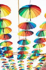 Obraz na płótnie Canvas Multi-colored umbrellas hanging over the street